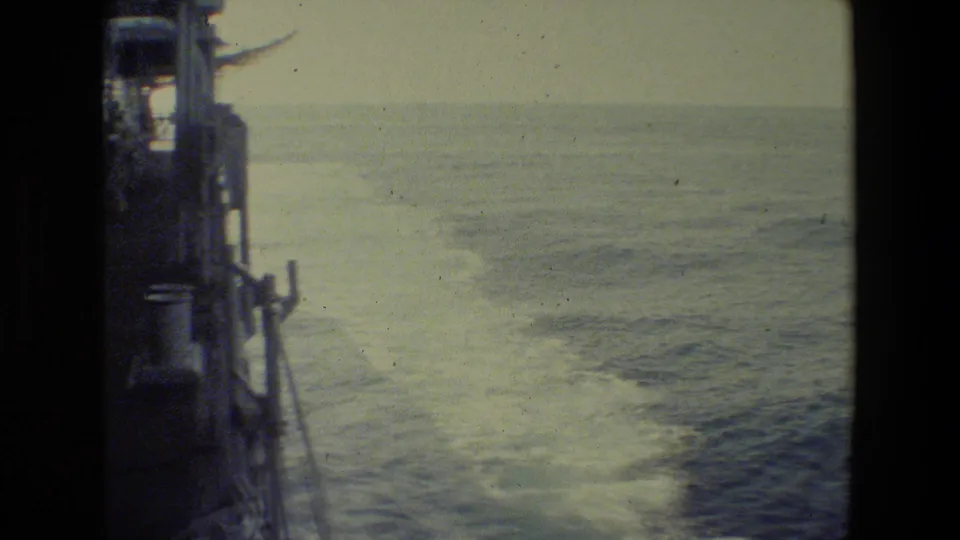 The final frame shows the ship's side and railing at the left edge with a broad view of foamy wake and open ocean in faded 8mm color.