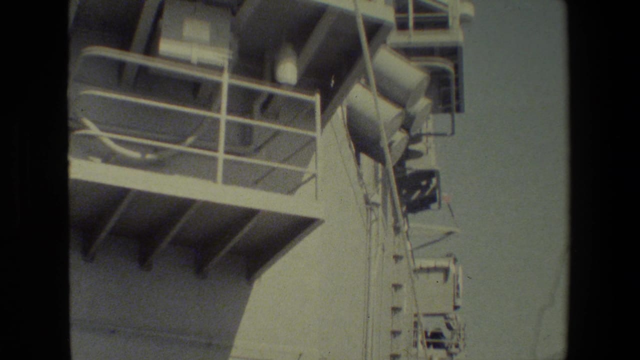White ship structure with upper railings, platform supports, and mounted equipment.