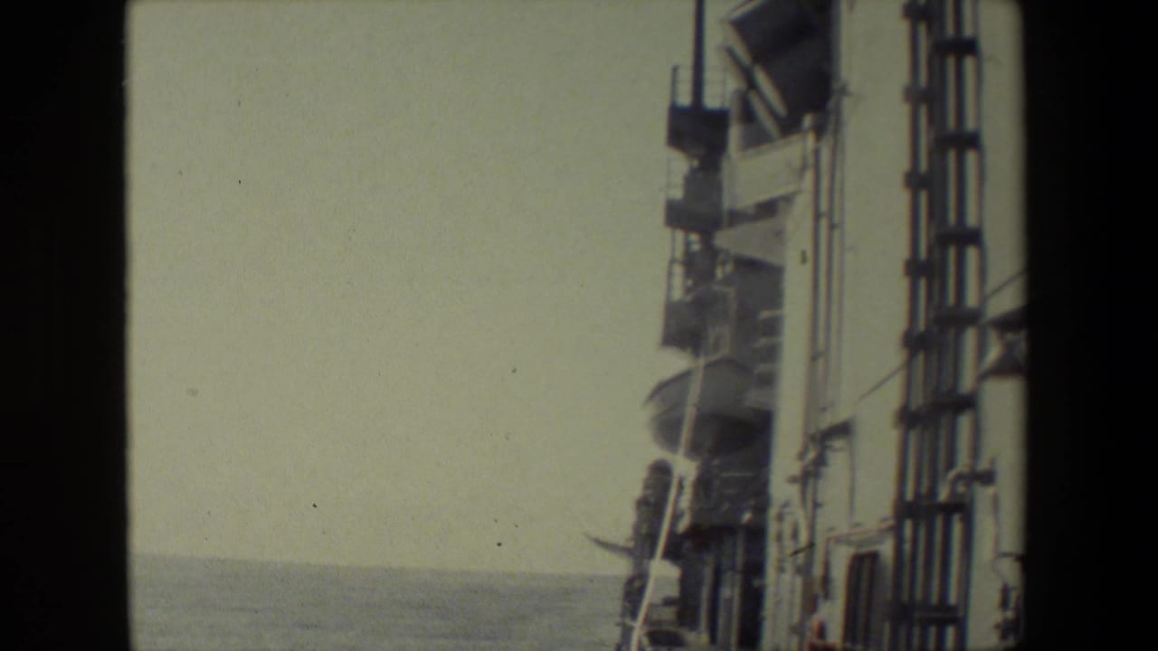 Close view of ship railings and fixtures with ocean visible to the left.