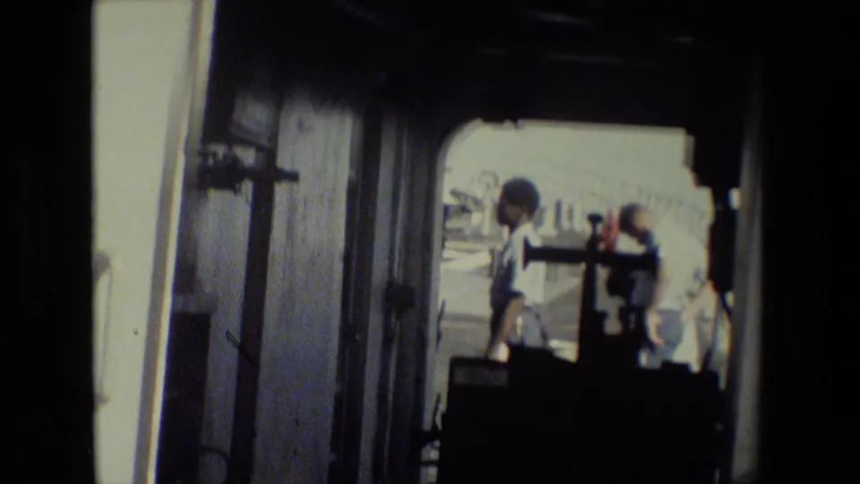 The final frame shows the shadowed trailer interior and doorway more prominently, with people in light clothing visible outside against an overexposed daylight background.