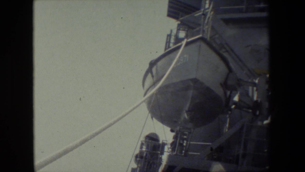Close view of a ship lifeboat or launch with rigging lines and ladders nearby.