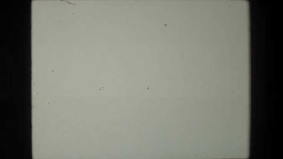 The frame appears largely washed out or between views, showing pale exposure, film grain, dust specks, and the contact-sheet frame border.