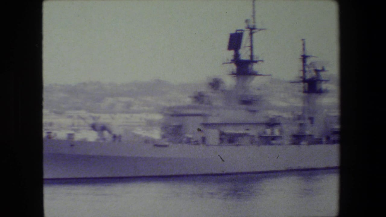 Side view of a gray military vessel with masts and radar equipment.