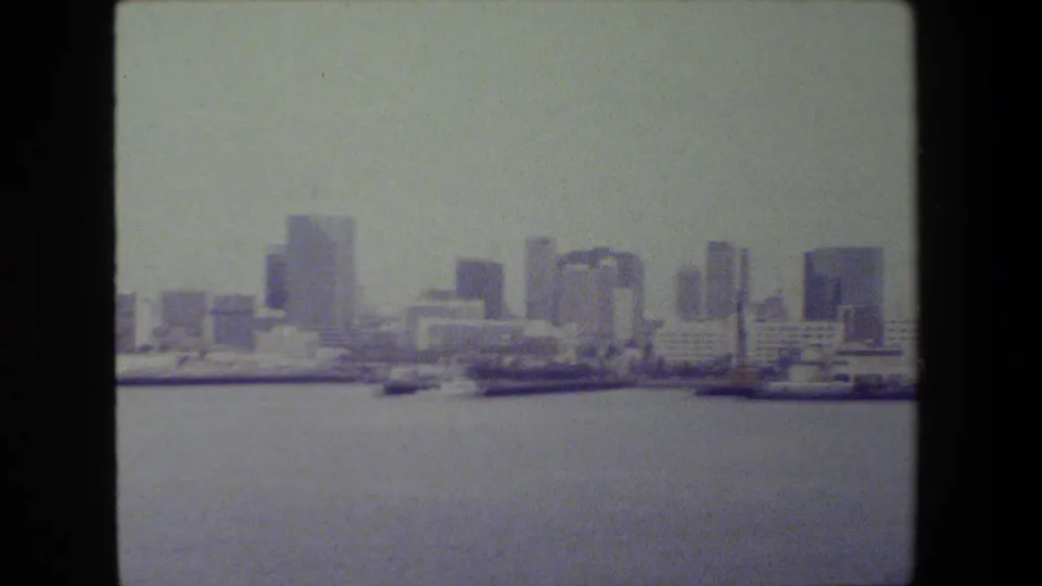 1981 San Diego port view with docked vessels and low waterfront buildings in front of clustered high-rises across the harbor.
