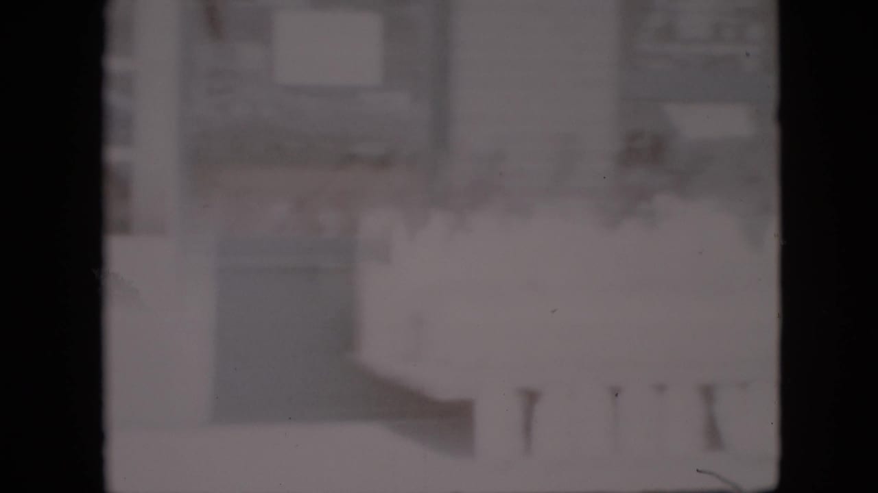 Overexposed 1958 Pennsylvania 8mm frame with a barely visible grocery-store interior, dark film borders, and indistinct counters or shelving.