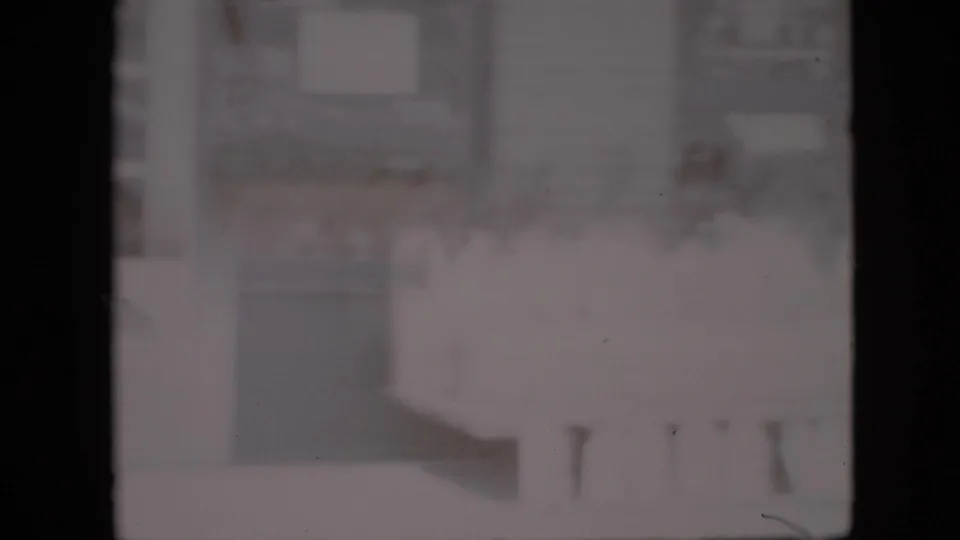 Overexposed 1958 Pennsylvania 8mm frame with a barely visible grocery-store interior, dark film borders, and indistinct counters or shelving.