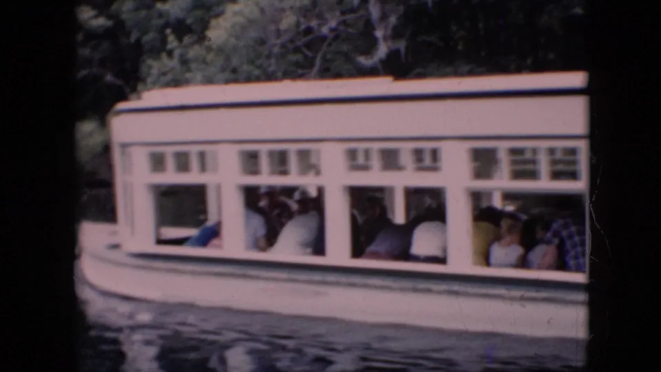 1958 Pennsylvania 8mm frame showing a white tour boat crowded with passengers, filmed from nearby on the water.