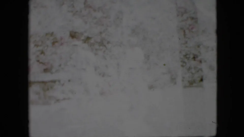 Late frame from a 1958 Pennsylvania 8mm clip showing a washed-out snowy exterior with faint trees and no identifiable people or signs.