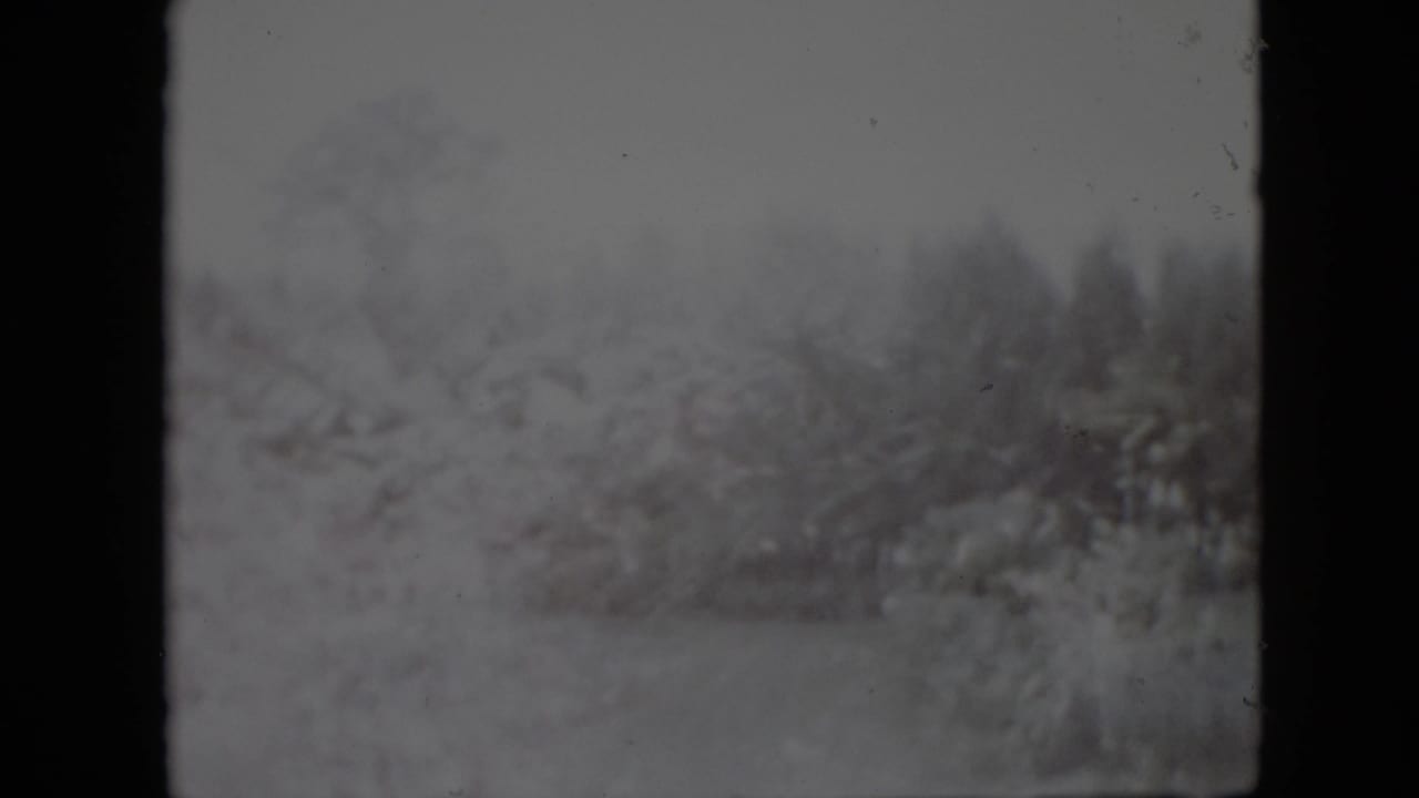 Snowy outdoor landscape with soft double exposure and dark vertical film border.
