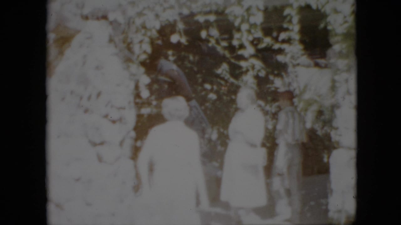Two adult women in light period clothing stand beside a large tree in a Pennsylvania residential yard, supported by the 1958 clip metadata.