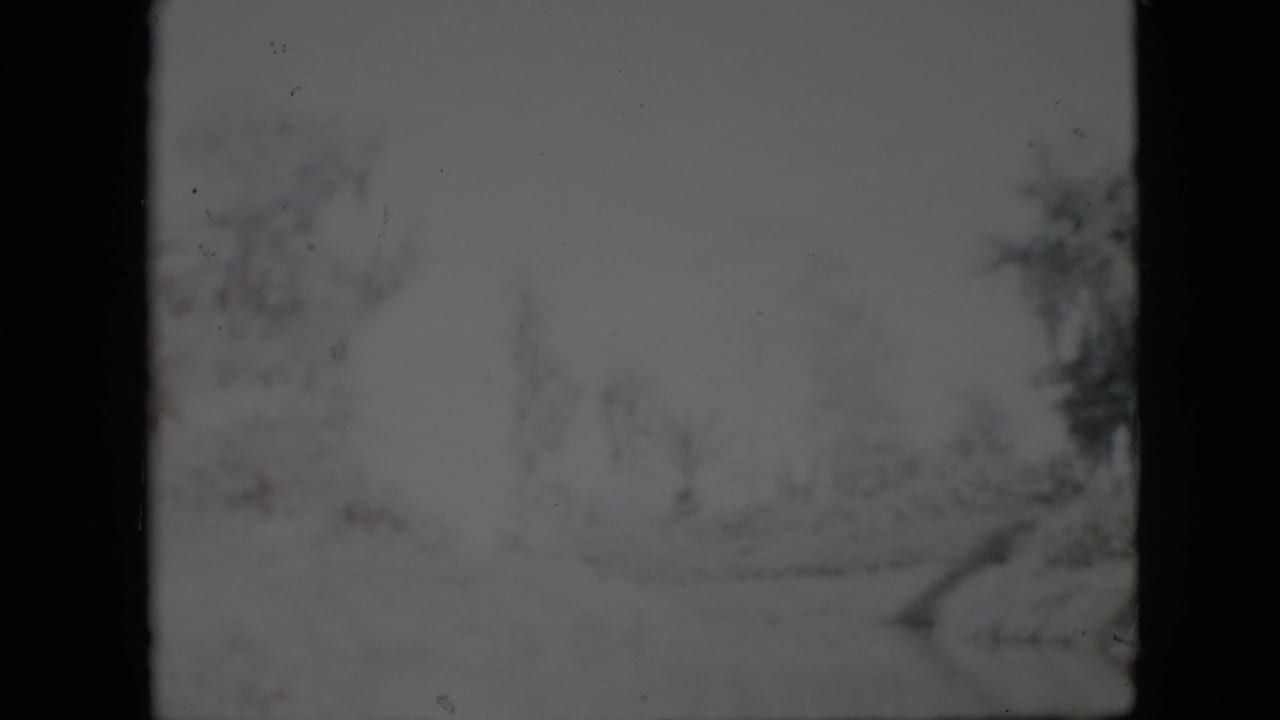 1958 Pennsylvania 8mm frame showing a soft, snowy outdoor path or lane with bare trees and dark film borders.