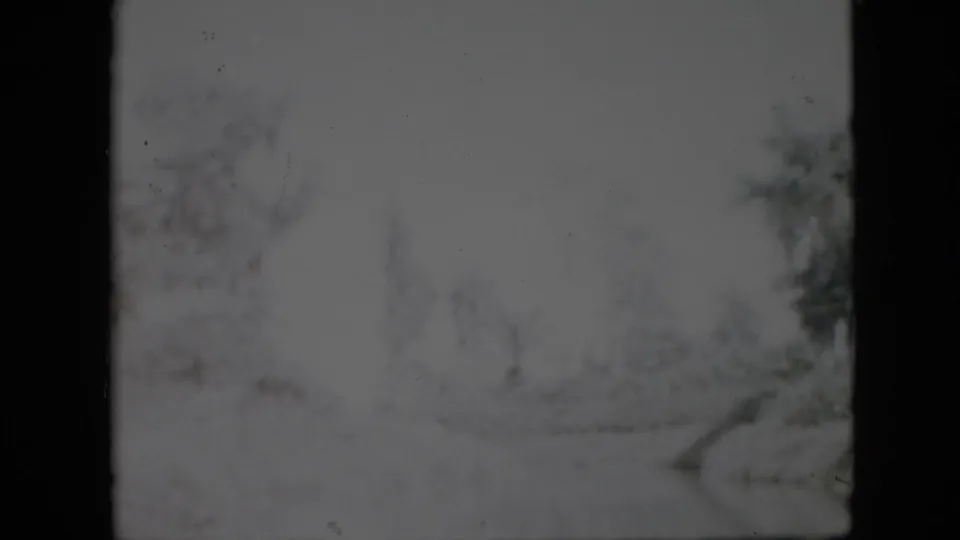 1958 Pennsylvania 8mm frame showing a soft, snowy outdoor path or lane with bare trees and dark film borders.