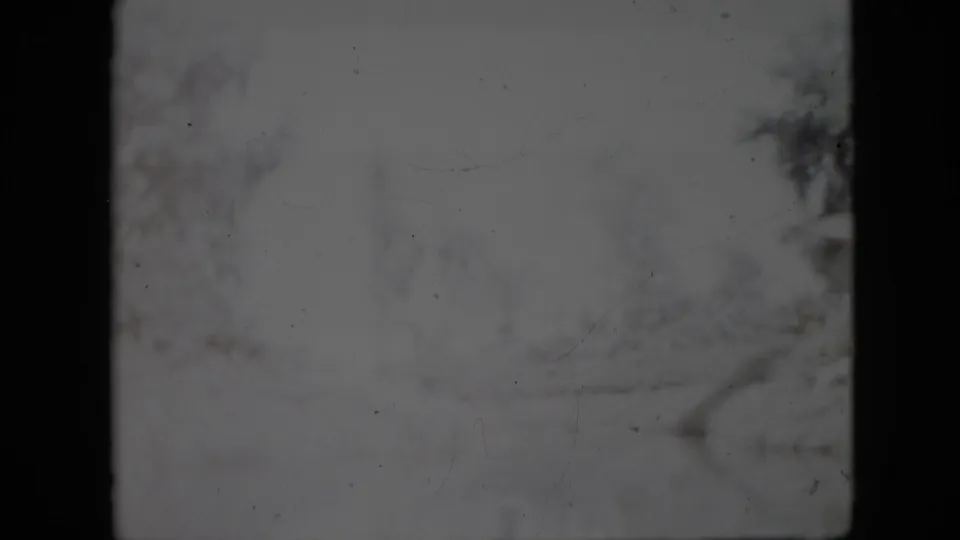 Pale 1958 Pennsylvania 8mm winter frame showing a washed snowy path, bare trees, and visible surface specks from the film scan.