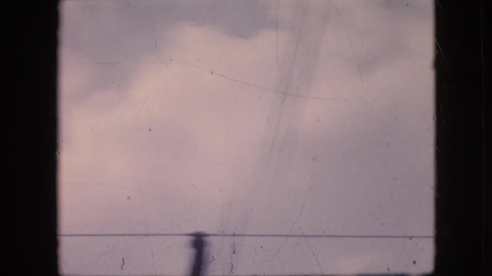 Final 1964 Philadelphia sky frame with muted clouds, a horizontal overhead wire, dark frame borders, and a pole-like vertical shape near the lower edge.