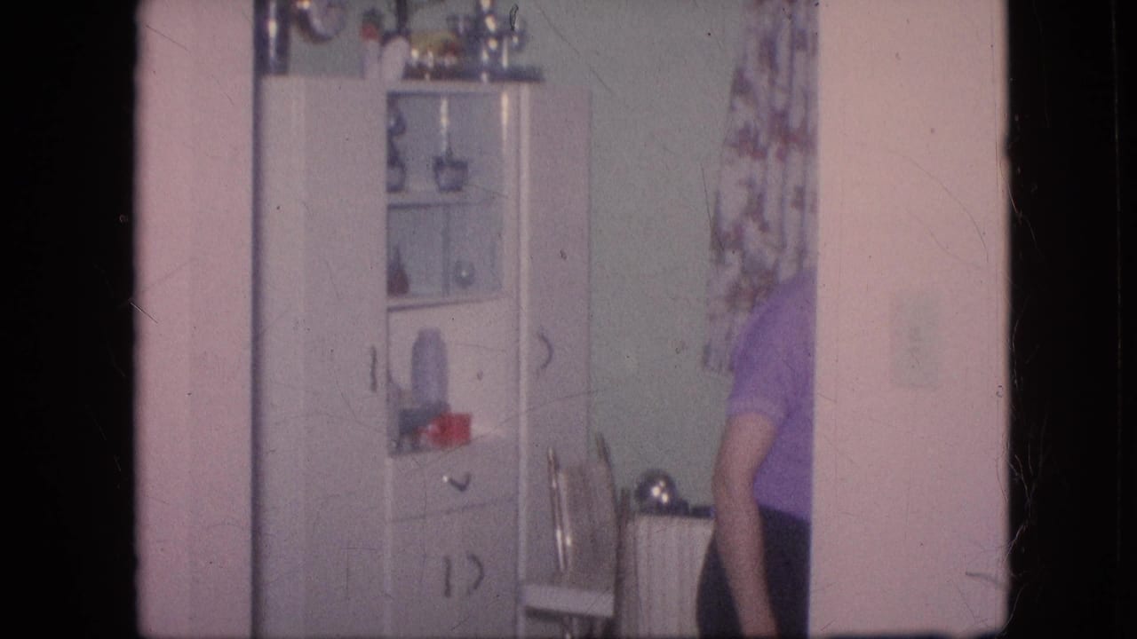 Woman partly out of frame near a white cabinet and patterned curtain.