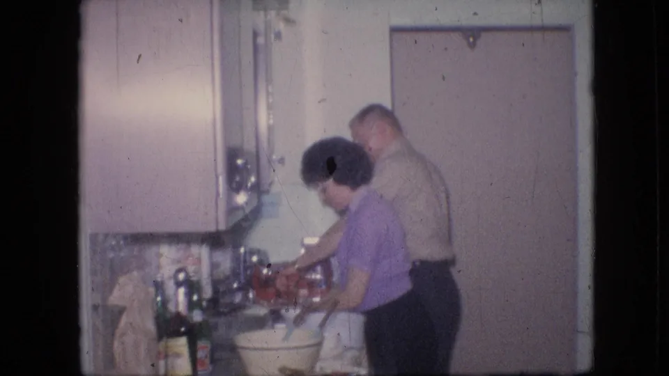 The final frame shows the woman reaching across the sink area as the man looks on from behind, with the pastel cabinets and countertop items still visible in the private Philadelphia kitchen.