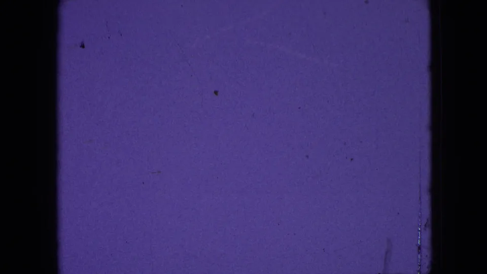 Final purple leader frame in the 1964 8mm clip, showing a mostly blank tinted field with grain, scattered dust, faint scratches, and black contact-sheet borders.