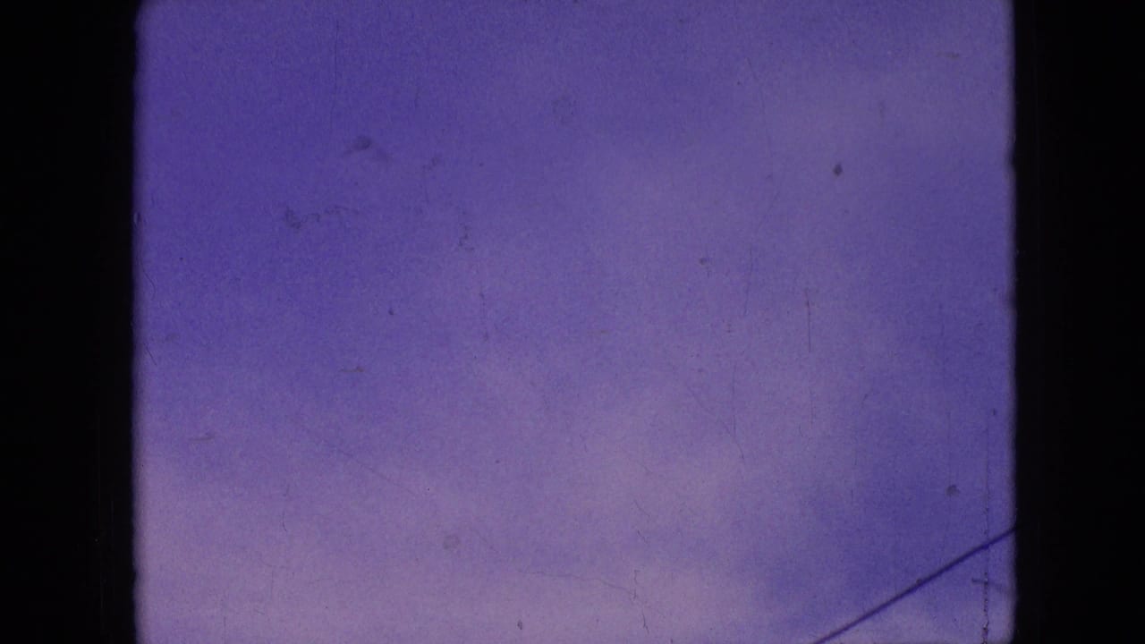1964 Philadelphia home-movie frame showing a purple-blue sky with faint clouds, visible film wear, and dark 8mm frame borders.