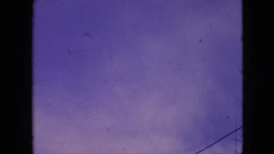 1964 Philadelphia home-movie frame showing a purple-blue sky with faint clouds, visible film wear, and dark 8mm frame borders.