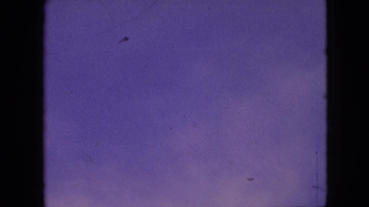 Open purple sky with faint specks, light cloud texture, scratches, and dark frame borders.
