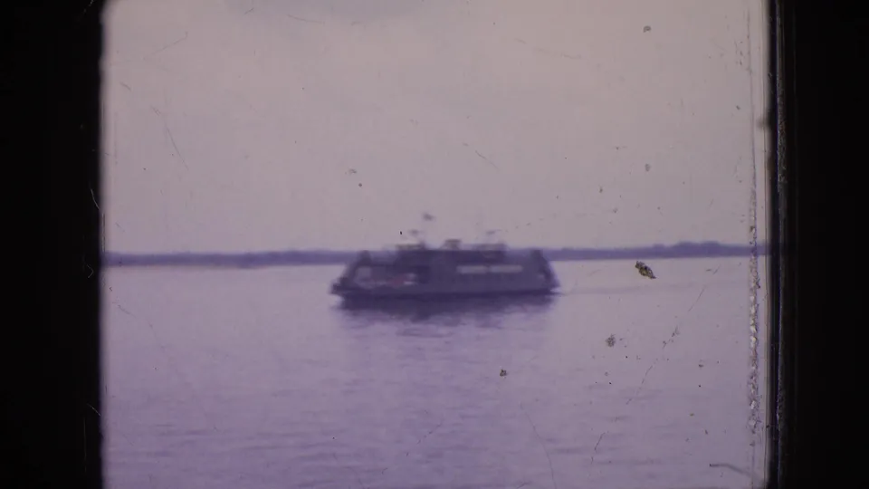 The passenger boat appears farther across the water in the 1964 Philadelphia clip, with a pale overcast sky, low shoreline, and visible film-gate borders.