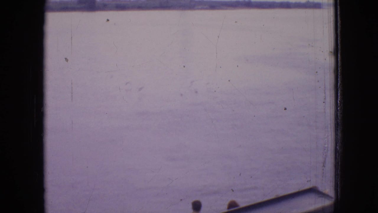 Wide water view with distant shore and a small boat edge at the bottom.