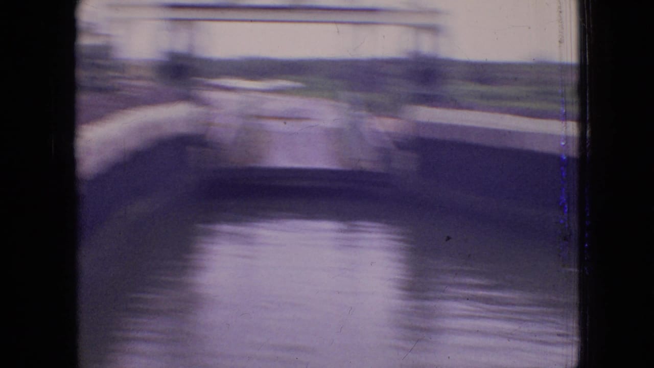 Blurred view of lock walls, water, and distant shoreline during movement.