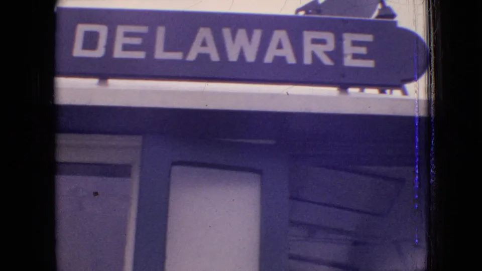 The 1964 8mm footage includes a close view of a large DELAWARE sign above industrial waterway structure or vessel detail.
