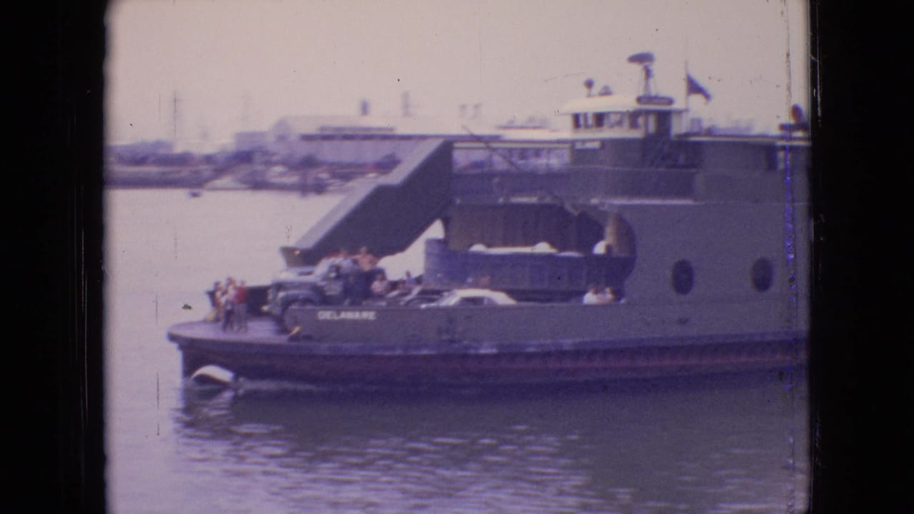 1964 Philadelphia-area home-movie frame showing a ferry marked CHESTER-BRIDGEPORT near a dock, with passengers visible on deck and water in the foreground.
