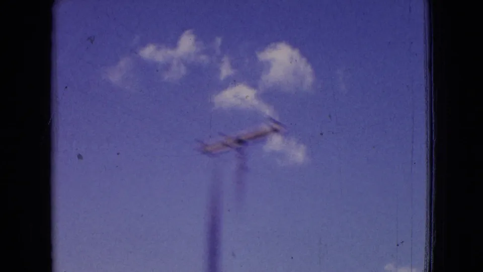 1965 New Jersey 8mm frame showing blue sky, small white clouds, and a utility pole passing quickly beside the road.