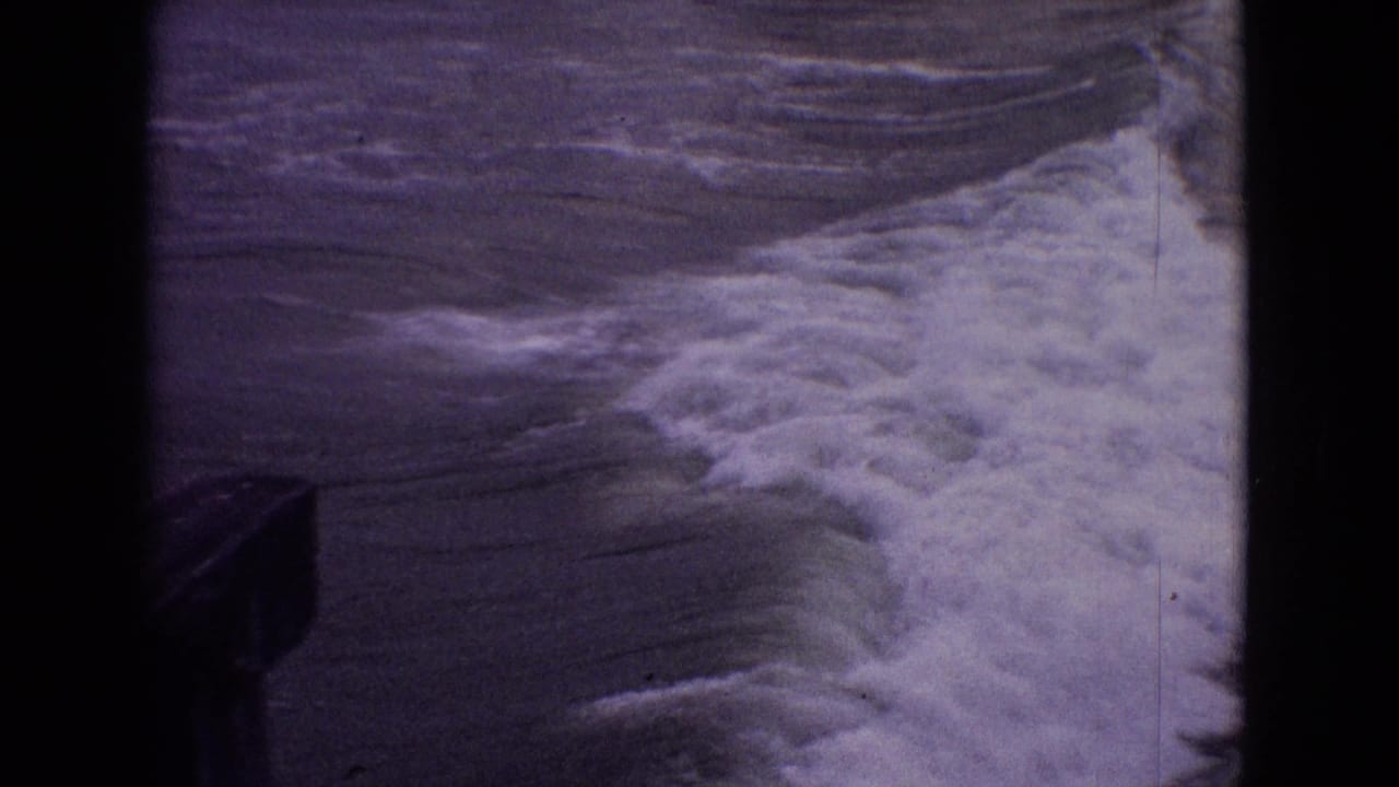White foamy water spreading near a dark structure at the lower left edge.