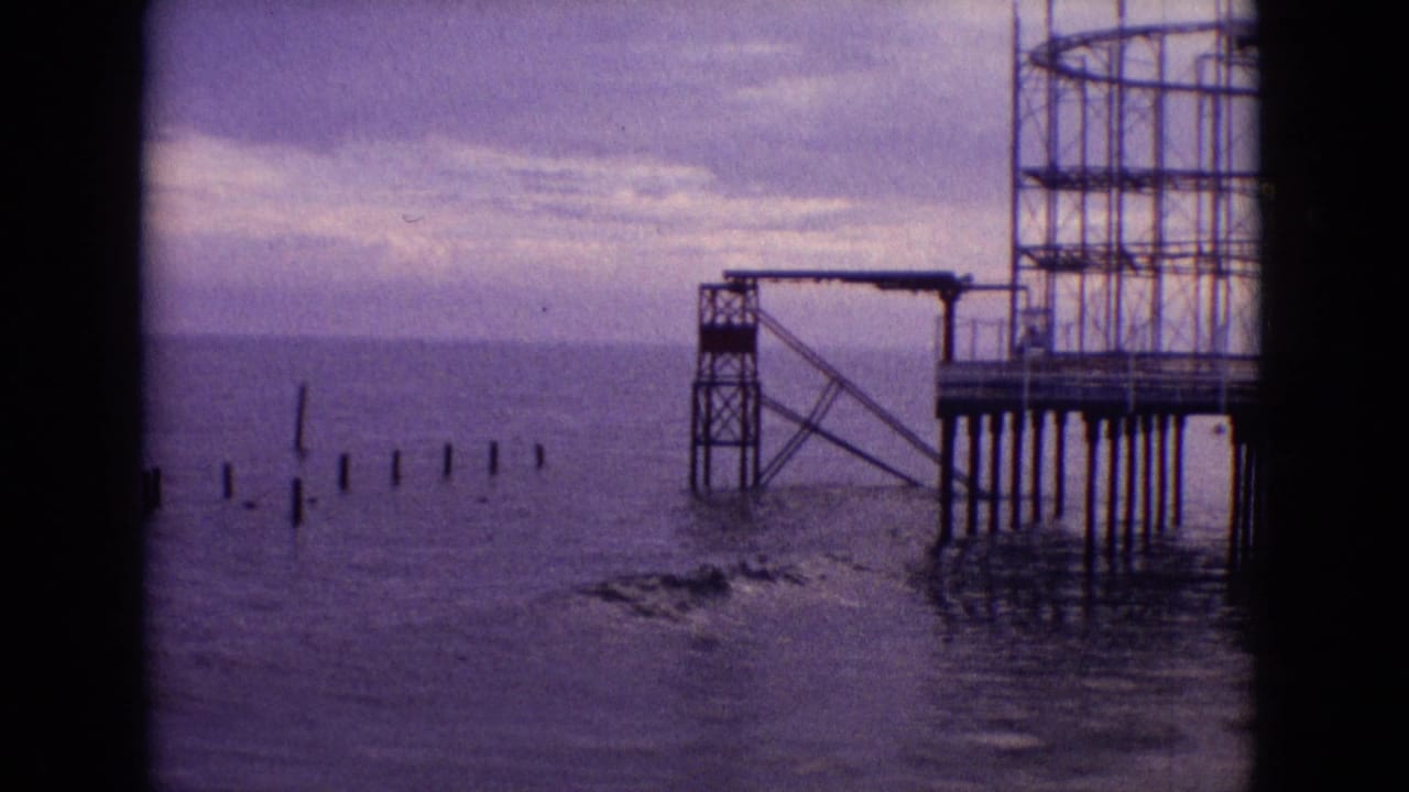 Weathered pier structure on pilings beside posts in the ocean.