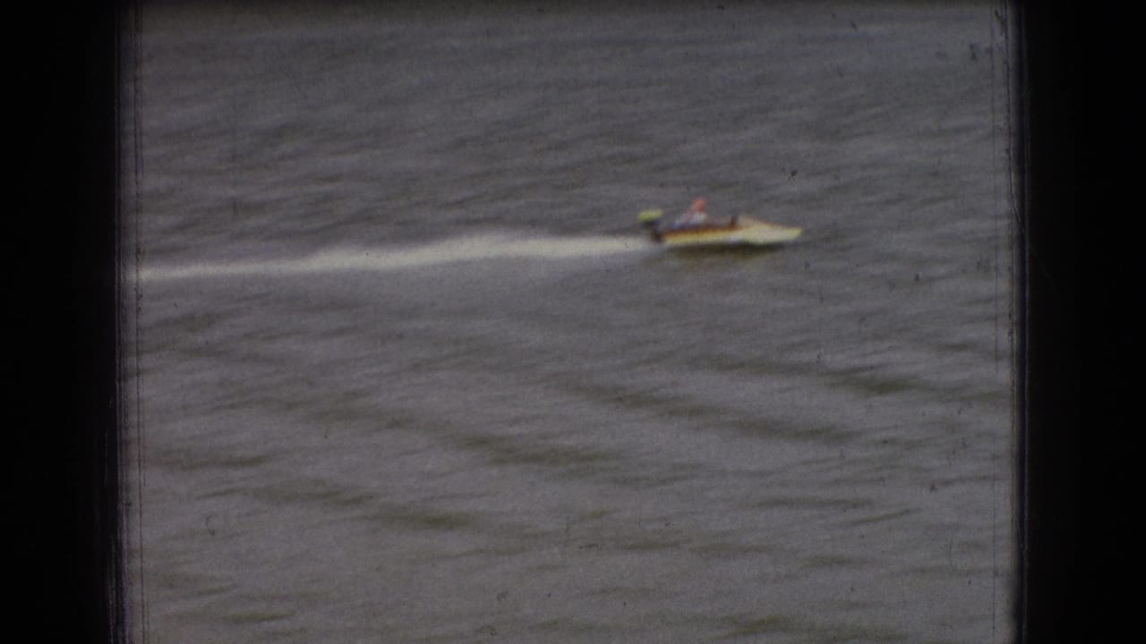 One small speedboat crosses the river, trailing a long white wake.