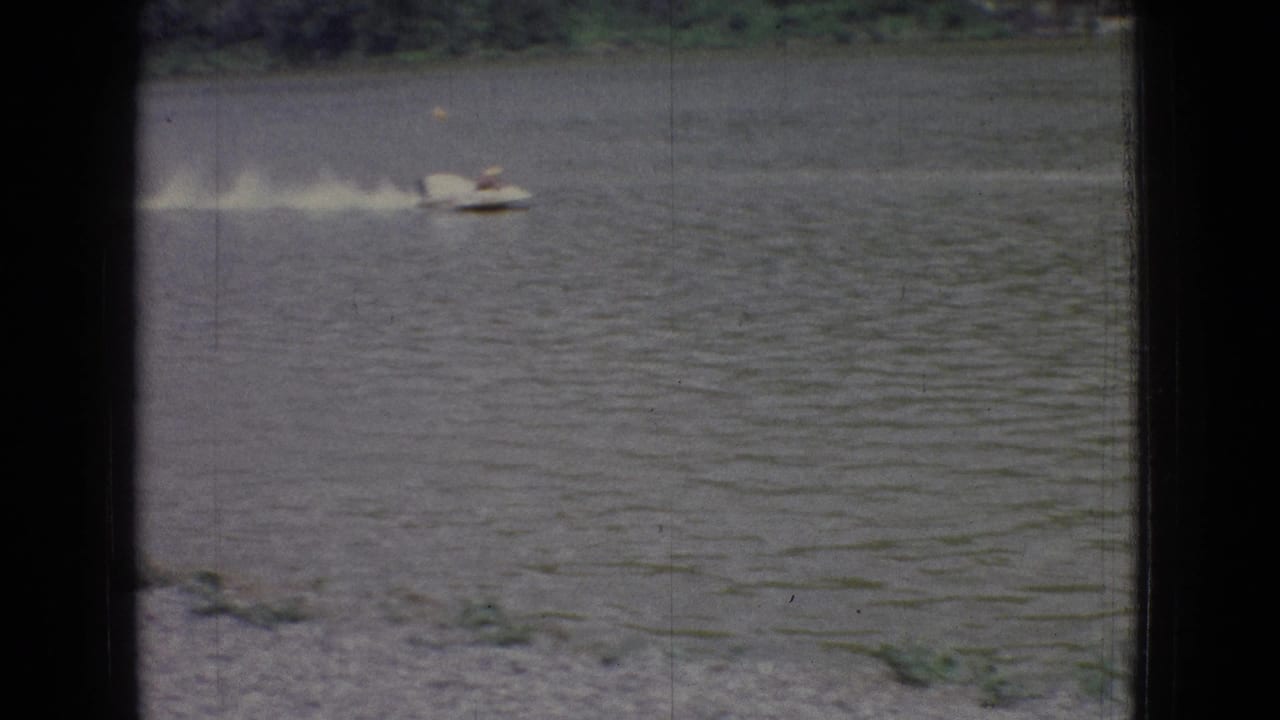 Speedboat moving along the lake with wake trailing behind.