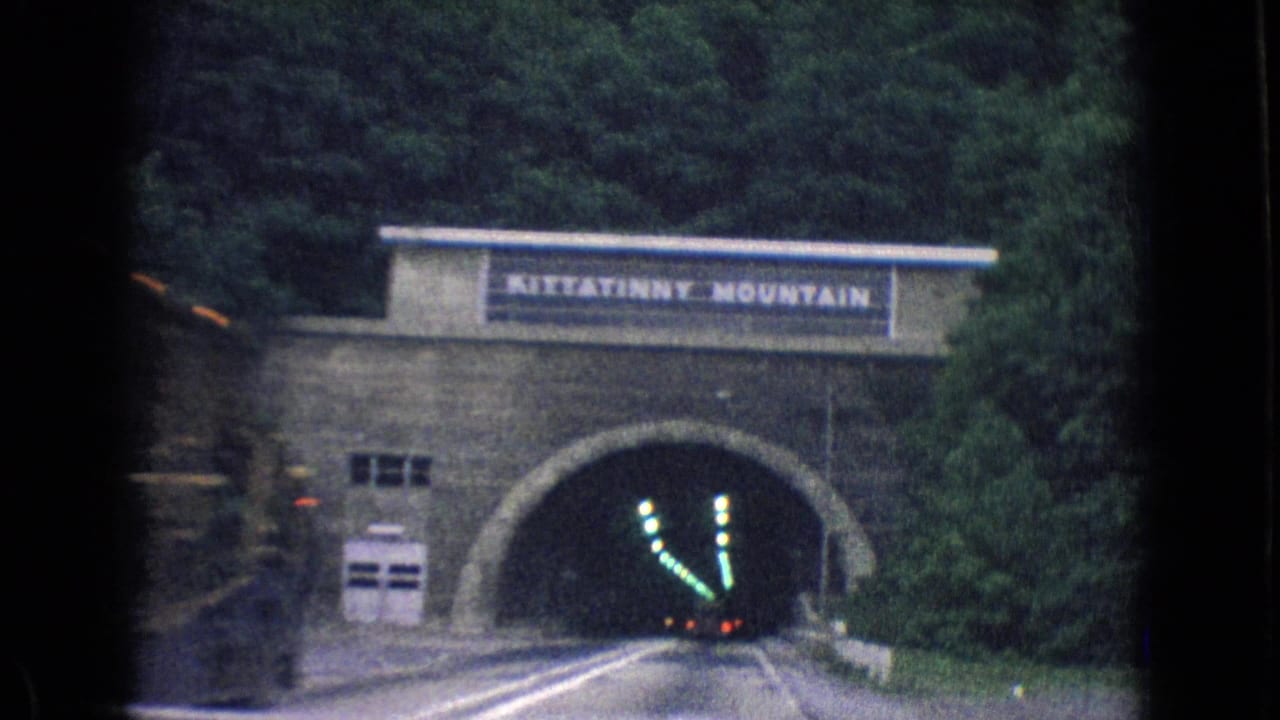 Tunnel portal marked Kittatinny Mountain with road lanes leading into the dark entrance.