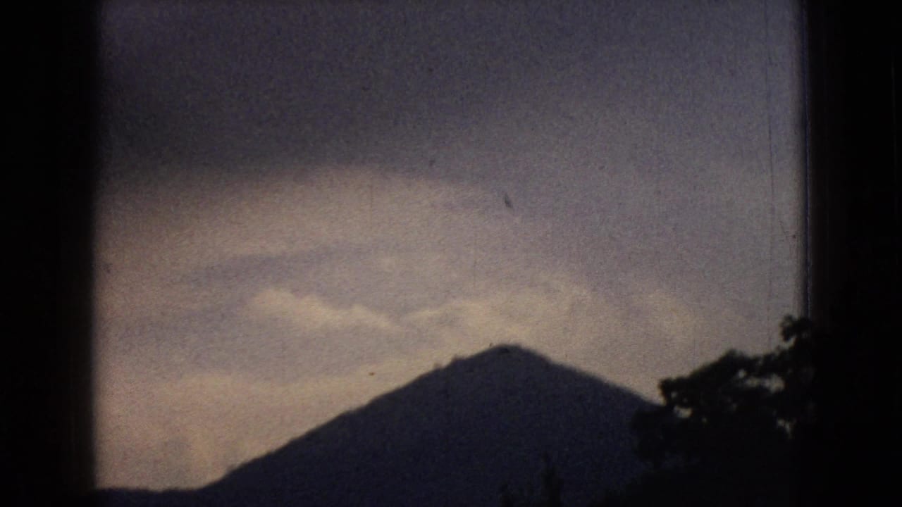 Dark hill peak silhouetted against a cloudy sky.