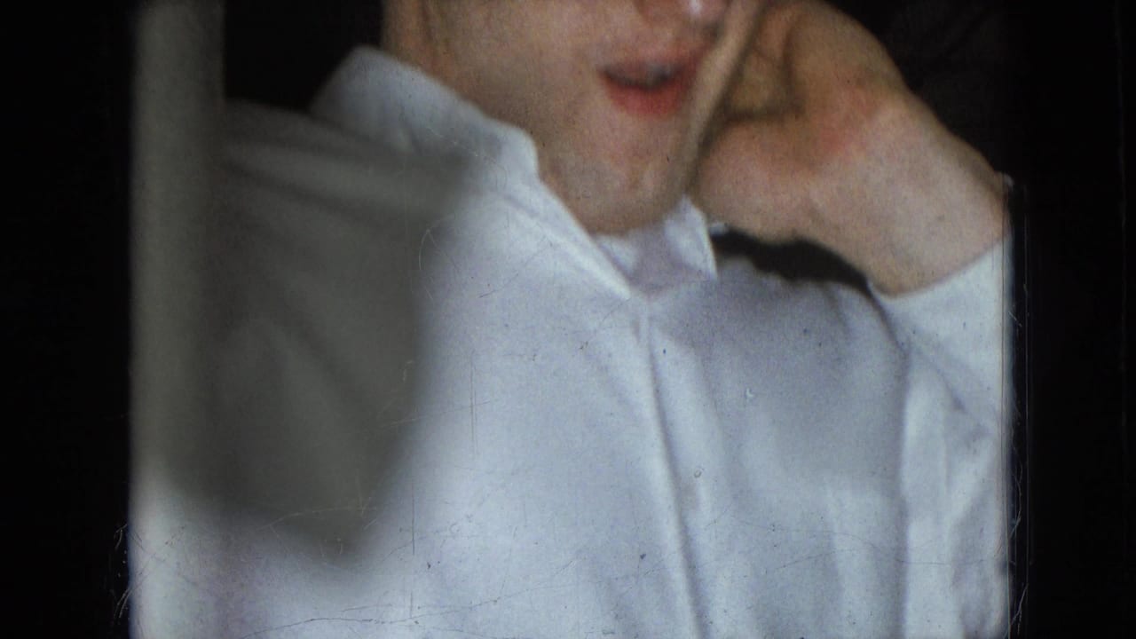 Partial view of a man in a white shirt with his hand near his face.