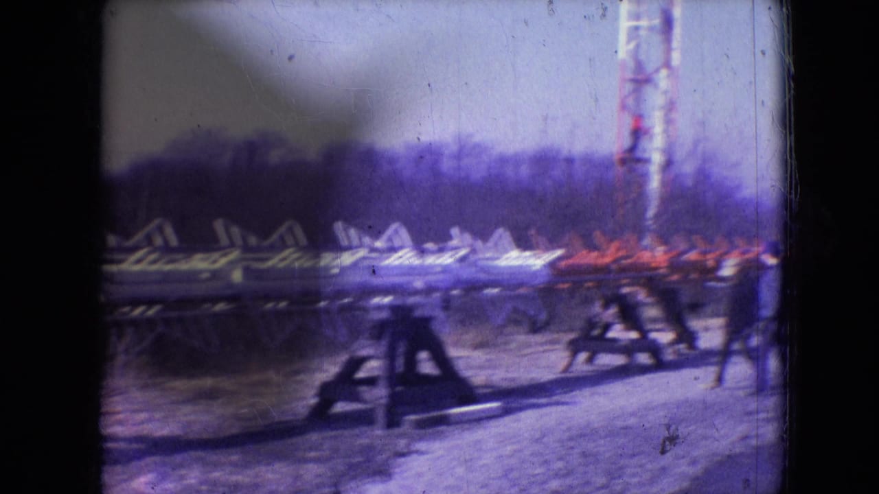 1966 Athens, Ohio 8mm frame showing stacked metal tower sections, wooden supports, and the lower area of a communication tower work site.