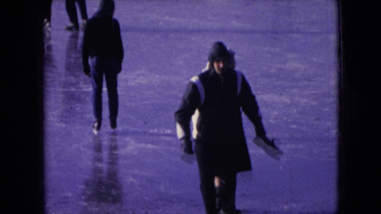 Bundled people skating across an outdoor ice surface.