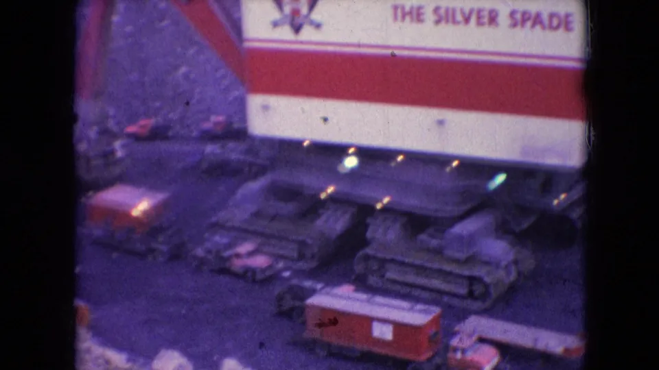 1966 Athens, Ohio frame showing a large tracked machine with visible lettering reading The Silver Spade, crawler treads, lights, and a red-and-white structure captured on aged 8mm film.
