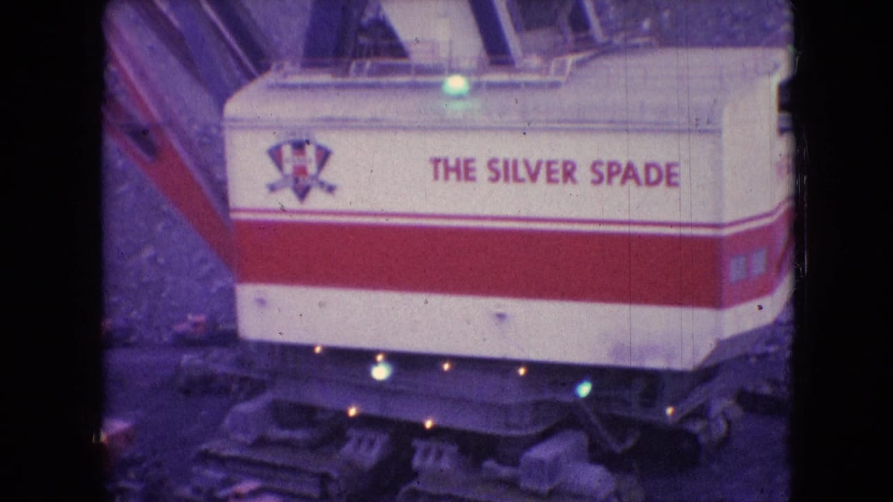 1966 8mm frame from Athens, Ohio showing the red-and-white Silver Spade machinery housing with readable lettering above rough mine earth.
