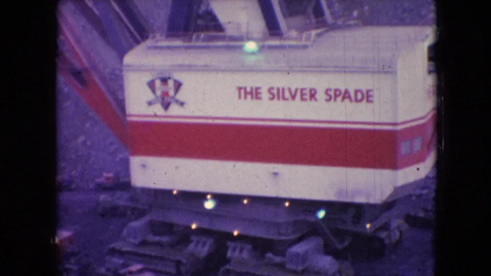 1966 8mm frame from Athens, Ohio showing the red-and-white Silver Spade machinery housing with readable lettering above rough mine earth.