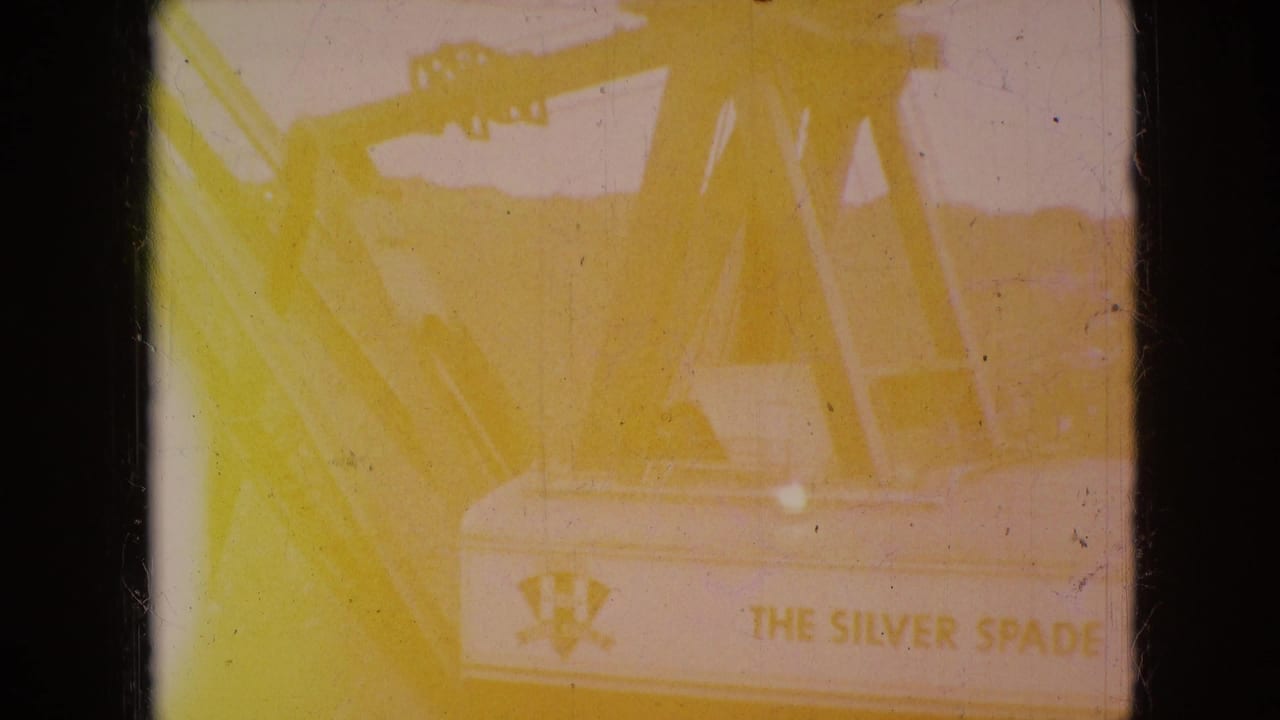 Overexposed yellow frame with partial machinery detail and faint readable signage.