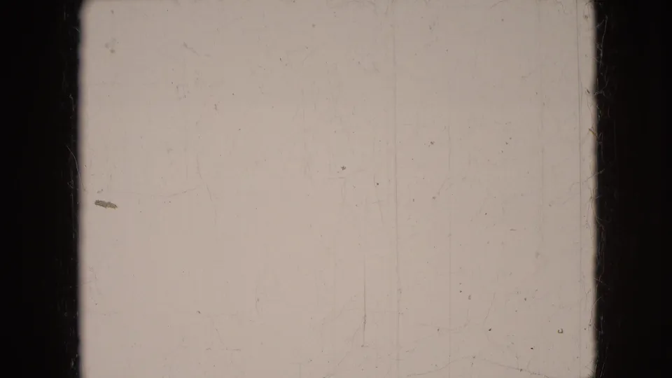 Pale blank 8mm leader frame from the same clip, showing gate edges, dust, scratches, and aged film texture rather than a photographed scene.