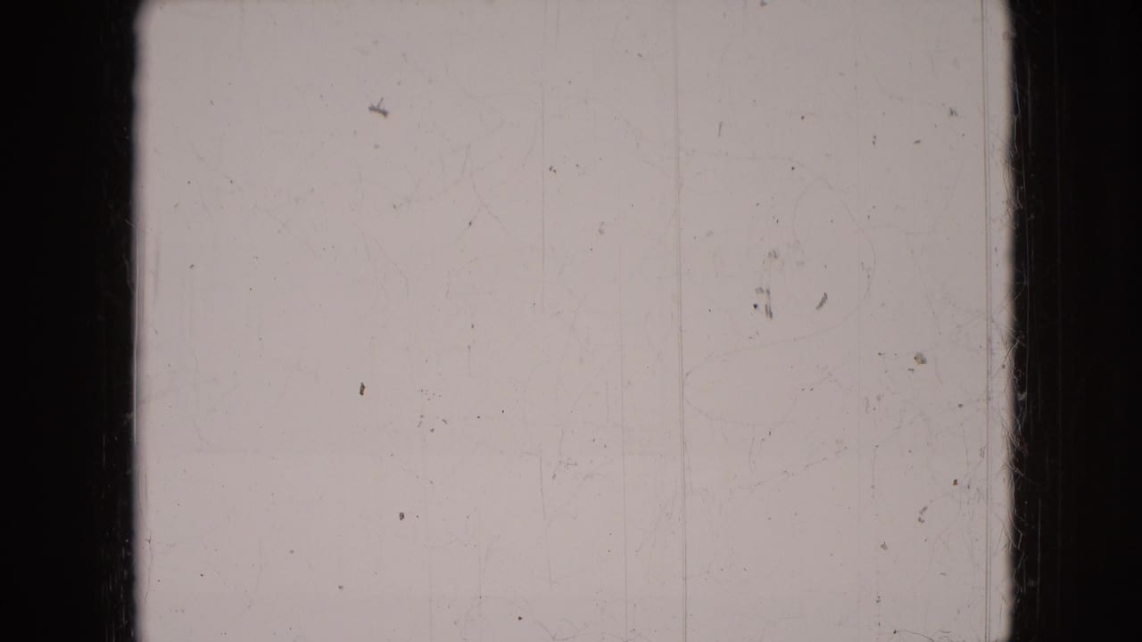 Blank scratched film frame with central dark divider and film wear.