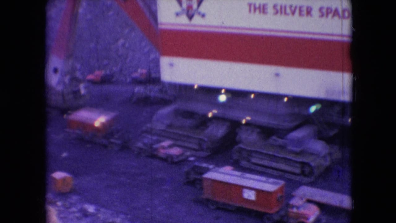 Side view of the Silver Spade machine with crawler tracks and small vehicles below.