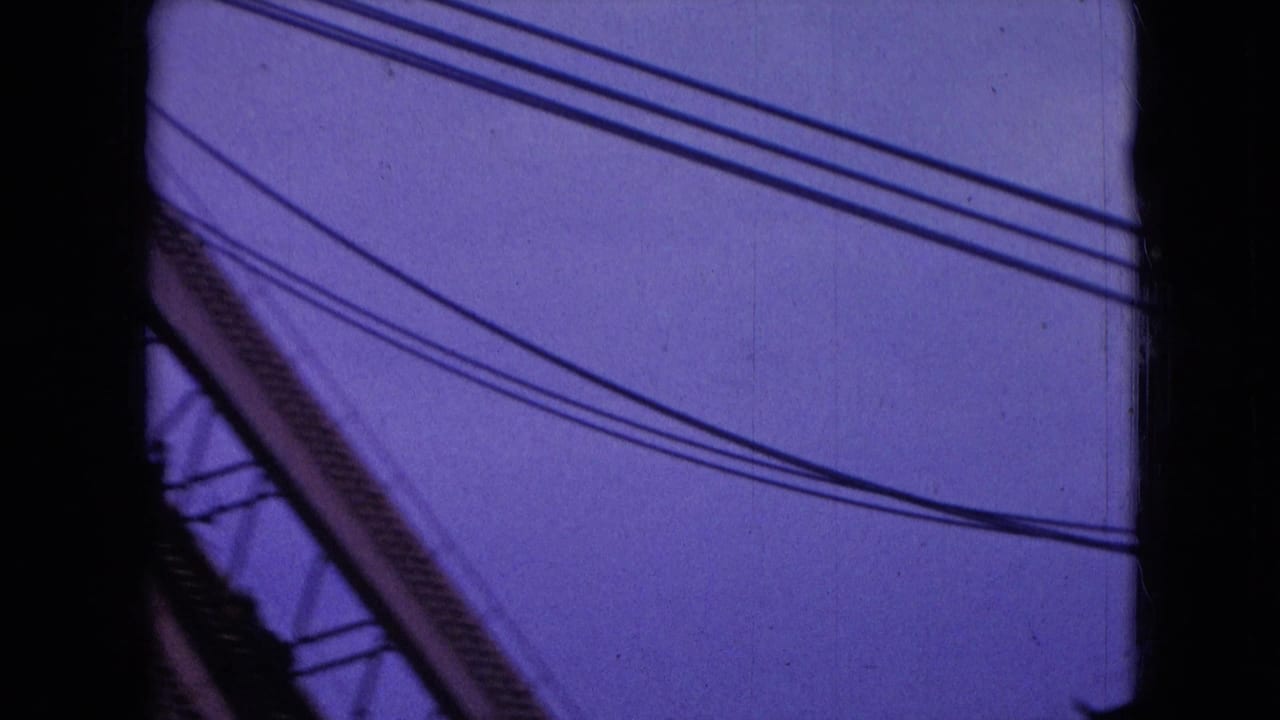 Diagonal industrial boom and overhead wires against a purple sky.