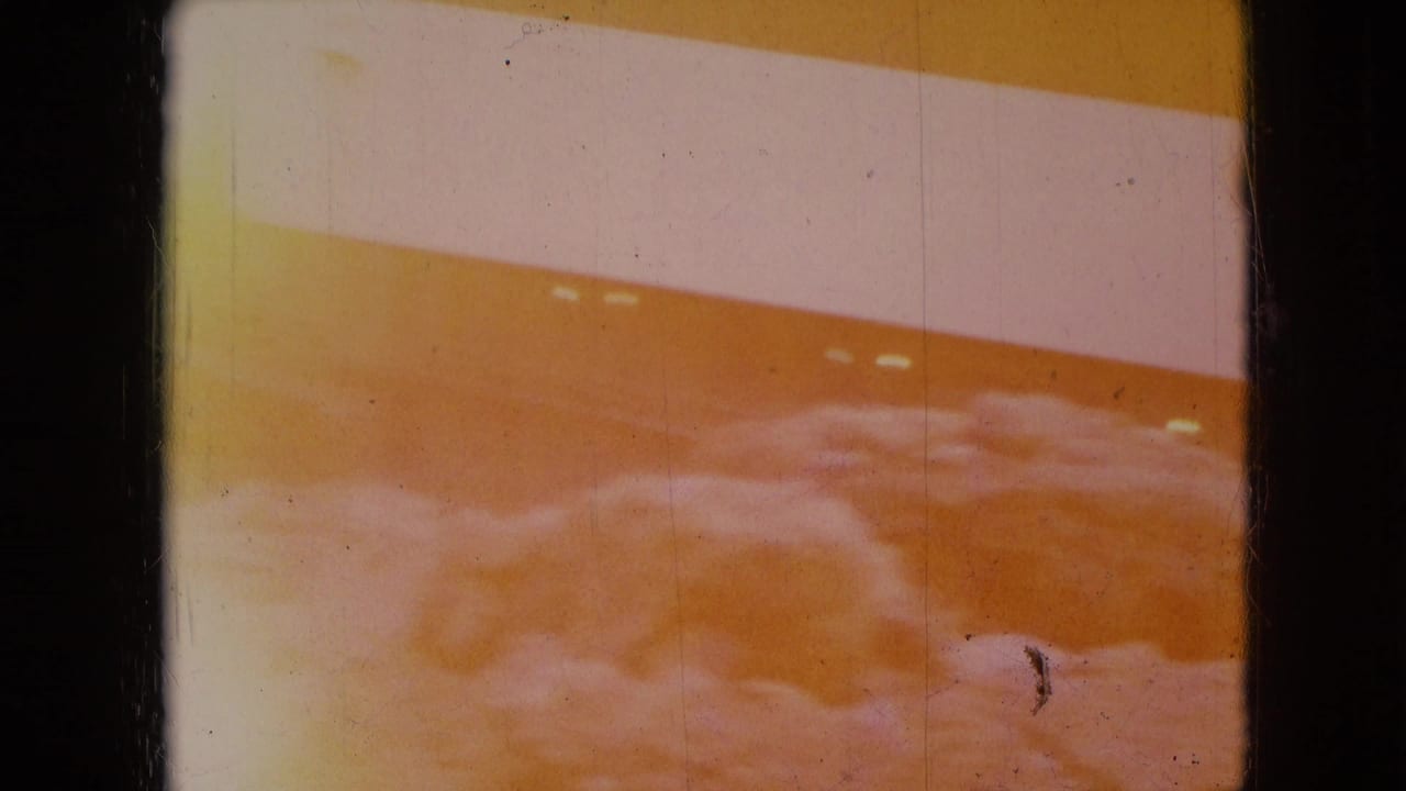 Overexposed orange-tinted view of a striped structure with snow or pale ground below.