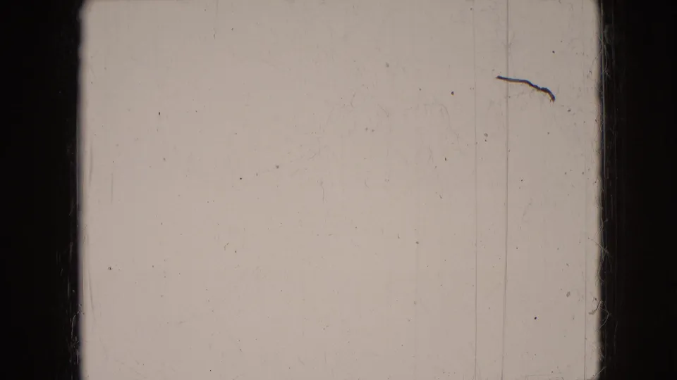 Mostly blank or overexposed 8mm frame from the 1966 Athens, Ohio clip, showing pale film area, gate edges, scratches, and dust rather than a clear subject.