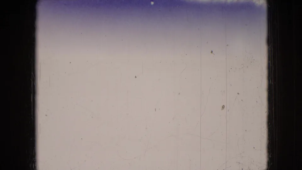 Mostly overexposed 8mm frame from the 1966 Athens, Ohio clip, with a blue-tinted upper edge, pale field, gate border, and visible dust and scratches.